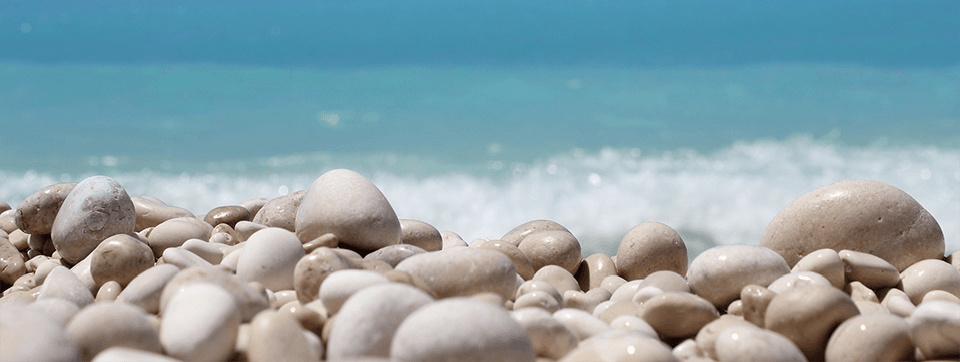 Novus white pebbles with the crashing waves in the background